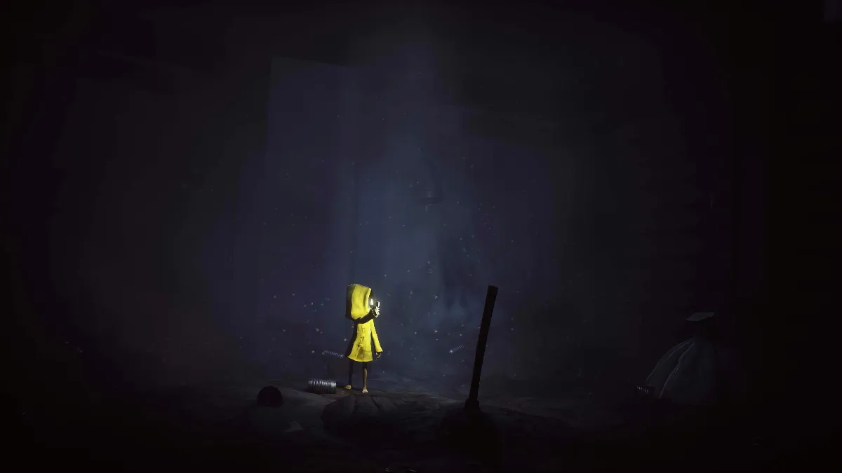 سیکس با بارانی زرد و فندکی روشن در اتاقی تاریک و پر از قوطی‌های خالی در لیتل نایتمرز (Little Nightmares)